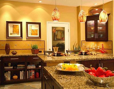 ロサンゼルスにある高級な広いコンテンポラリースタイルのおしゃれなキッチン (インセット扉のキャビネット、濃色木目調キャビネット、御影石カウンター、黄色いキッチンパネル、ガラスタイルのキッチンパネル、シルバーの調理設備) の写真