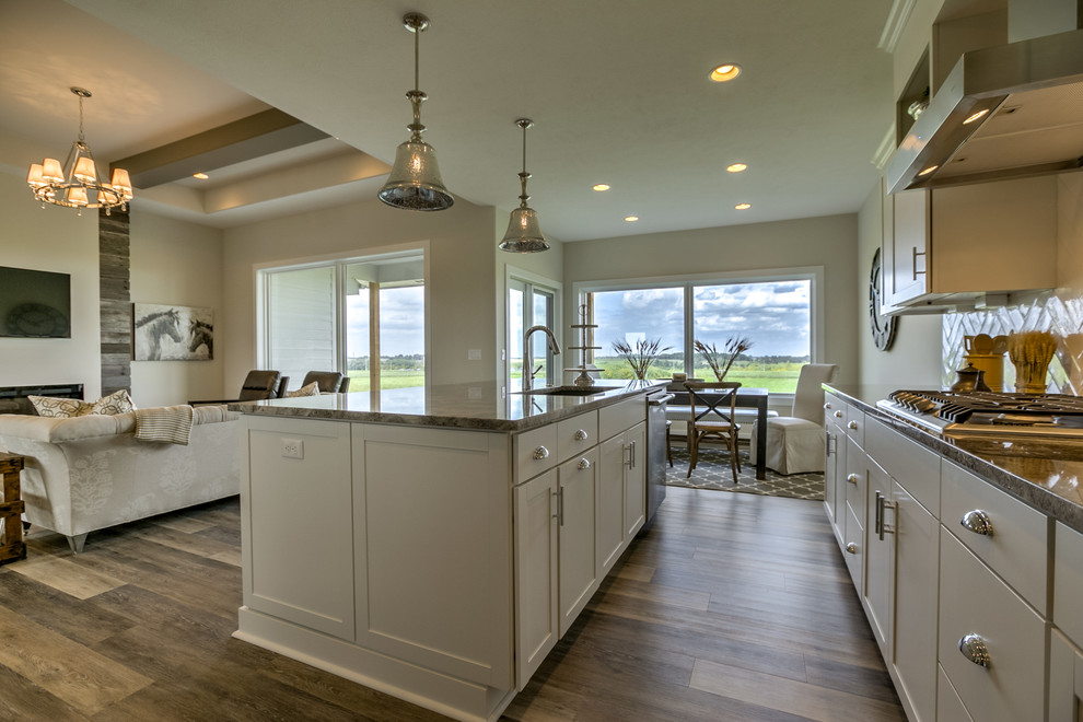 Exempel på ett klassiskt kök med öppen planlösning, med en undermonterad diskho, skåp i shakerstil, vita skåp, granitbänkskiva, vitt stänkskydd, rostfria vitvaror och en köksö