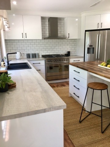 Klassische Küche mit weißen Schränken, Kalkstein-Arbeitsplatte, Küchenrückwand in Weiß, Rückwand aus Metrofliesen und Kücheninsel in Brisbane