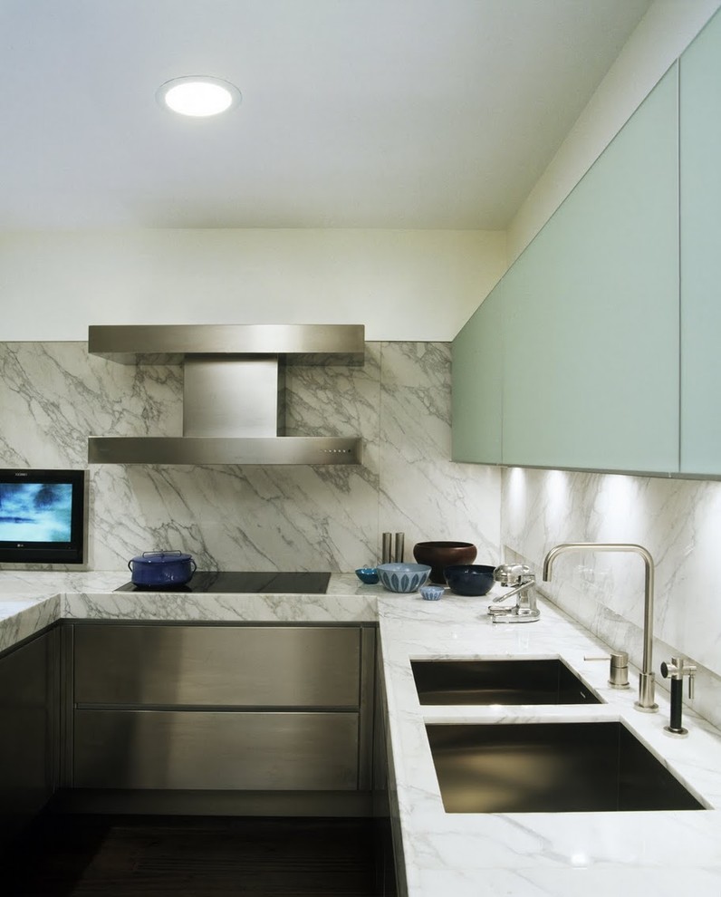 Inspiration for a modern kitchen remodel in New York with marble countertops, a double-bowl sink, flat-panel cabinets, stainless steel cabinets, white backsplash and stone slab backsplash