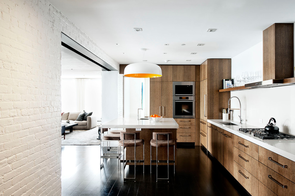 Cette photo montre une cuisine industrielle en bois foncé avec un placard à porte plane, un plan de travail en quartz modifié, une crédence blanche et un électroménager en acier inoxydable.