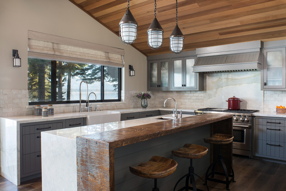 Inspiration for a coastal l-shaped dark wood floor, brown floor and wood ceiling kitchen remodel in Sacramento with a farmhouse sink, gray cabinets, multicolored backsplash, stone slab backsplash, stainless steel appliances, an island and white countertops