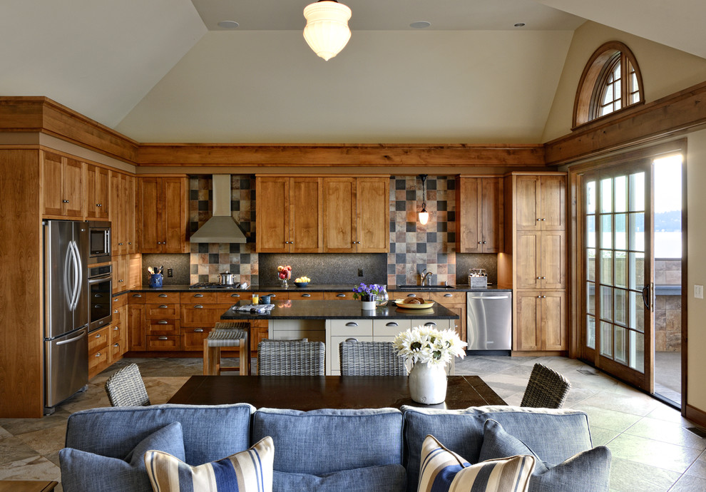 Klassisk inredning av ett kök, med skåp i shakerstil, skåp i mellenmörkt trä, flerfärgad stänkskydd, rostfria vitvaror och en köksö