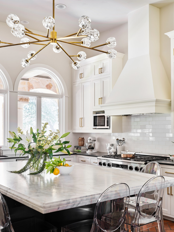 Immagine di un'ampia cucina chic con lavello sottopiano, ante in stile shaker, ante bianche, top in marmo, paraspruzzi bianco, paraspruzzi con piastrelle diamantate, elettrodomestici in acciaio inossidabile e pavimento in mattoni