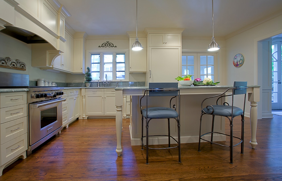 Bild på ett mellanstort vintage l-kök, med en undermonterad diskho, skåp i shakerstil, beige skåp, marmorbänkskiva, integrerade vitvaror, mellanmörkt trägolv och en köksö
