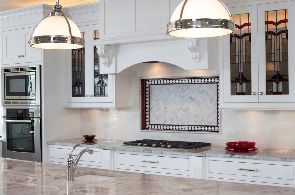 Immagine di una cucina chic di medie dimensioni con lavello sottopiano, ante in stile shaker, ante bianche, top in marmo, paraspruzzi bianco, paraspruzzi con piastrelle di vetro, elettrodomestici in acciaio inossidabile e parquet scuro