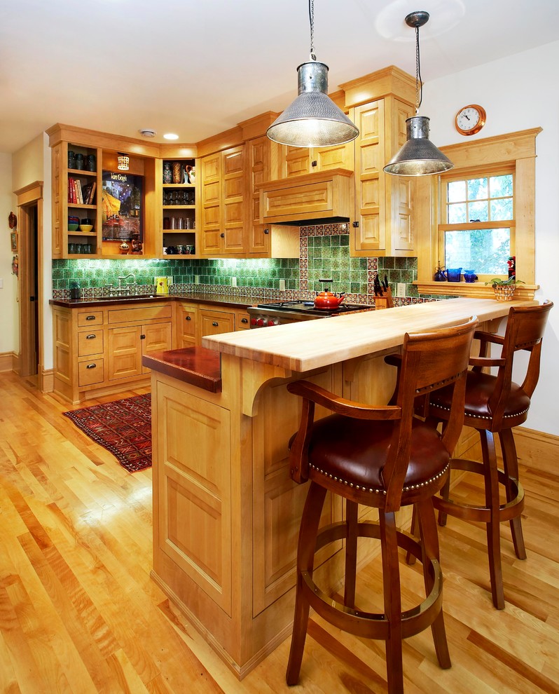 Mediterrane Küche in U-Form mit profilierten Schrankfronten, hellbraunen Holzschränken und Küchenrückwand in Grün in Minneapolis