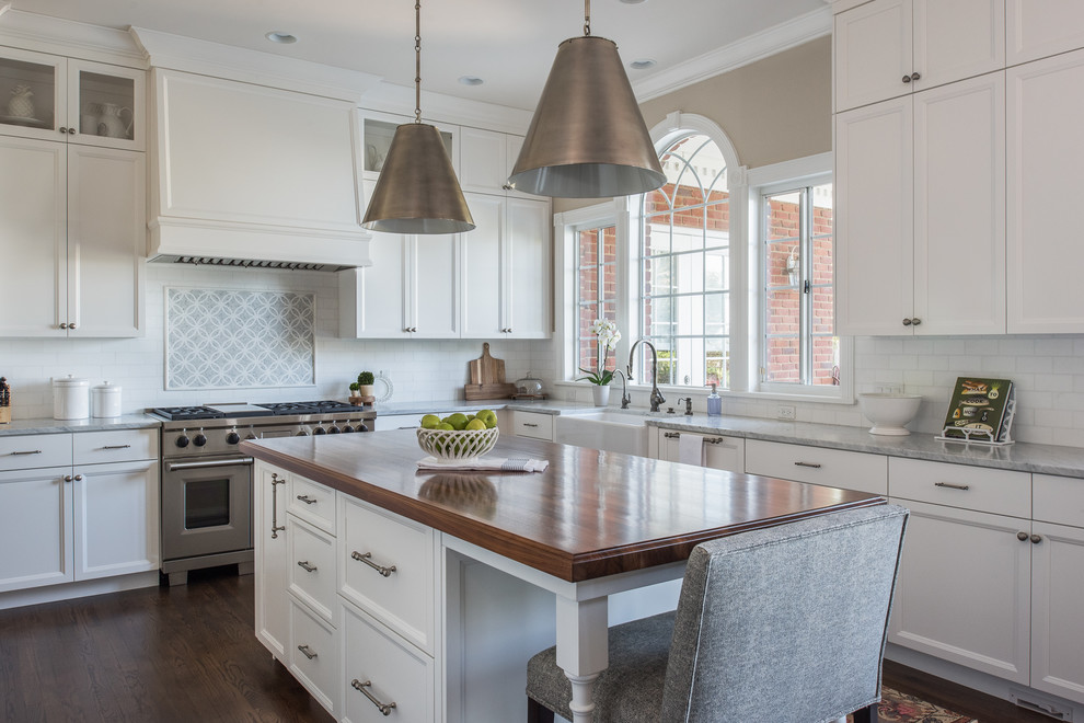 Kitchen - traditional l-shaped dark wood floor kitchen idea in Tampa with a farmhouse sink, recessed-panel cabinets, white cabinets, multicolored backsplash, stainless steel appliances and an island