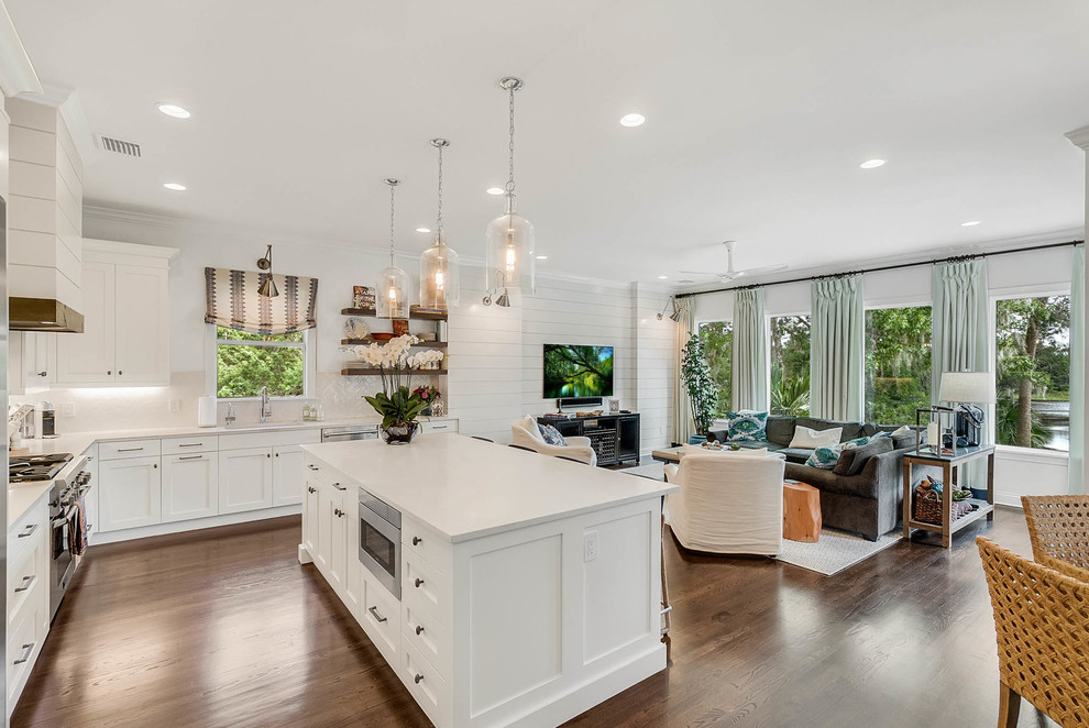 Inspiration for a large transitional l-shaped dark wood floor and brown floor open concept kitchen remodel in Orlando with an undermount sink, shaker cabinets, white cabinets, marble countertops, beige backsplash, ceramic backsplash, stainless steel appliances and an island