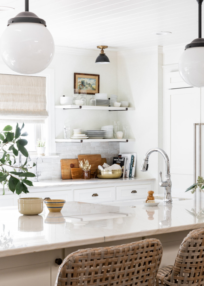 Foto på ett mellanstort vintage vit kök, med en rustik diskho, skåp i shakerstil, vita skåp, bänkskiva i kvartsit, vitt stänkskydd, stänkskydd i terrakottakakel, rostfria vitvaror, mellanmörkt trägolv, en köksö och brunt golv