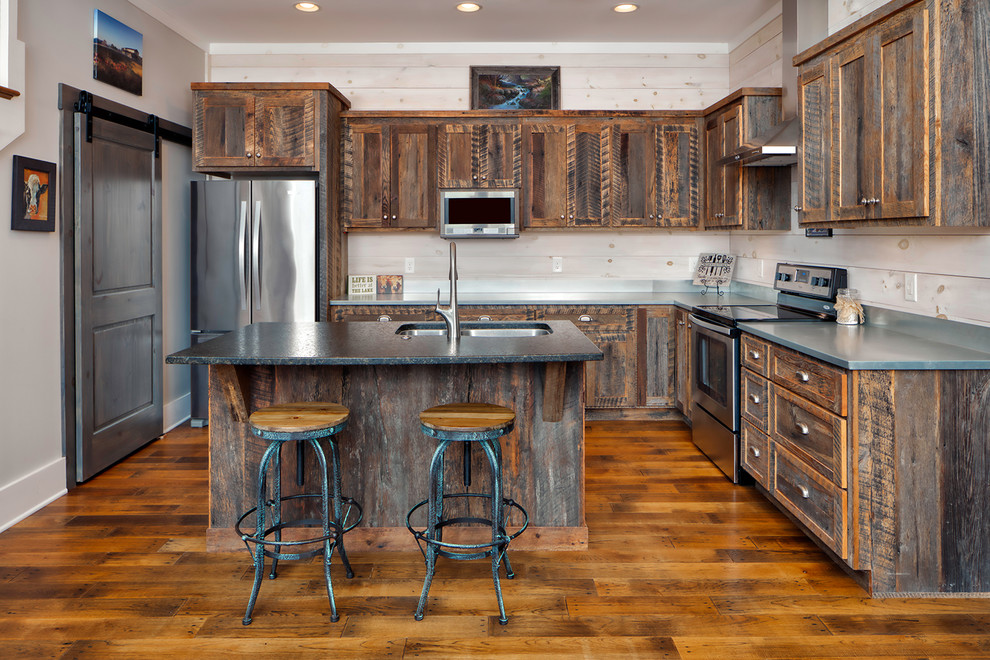 Medium sized rustic l-shaped kitchen in Other with a submerged sink, shaker cabinets, wood splashback, stainless steel appliances, medium hardwood flooring, an island, grey worktops, orange floors and distressed cabinets.
