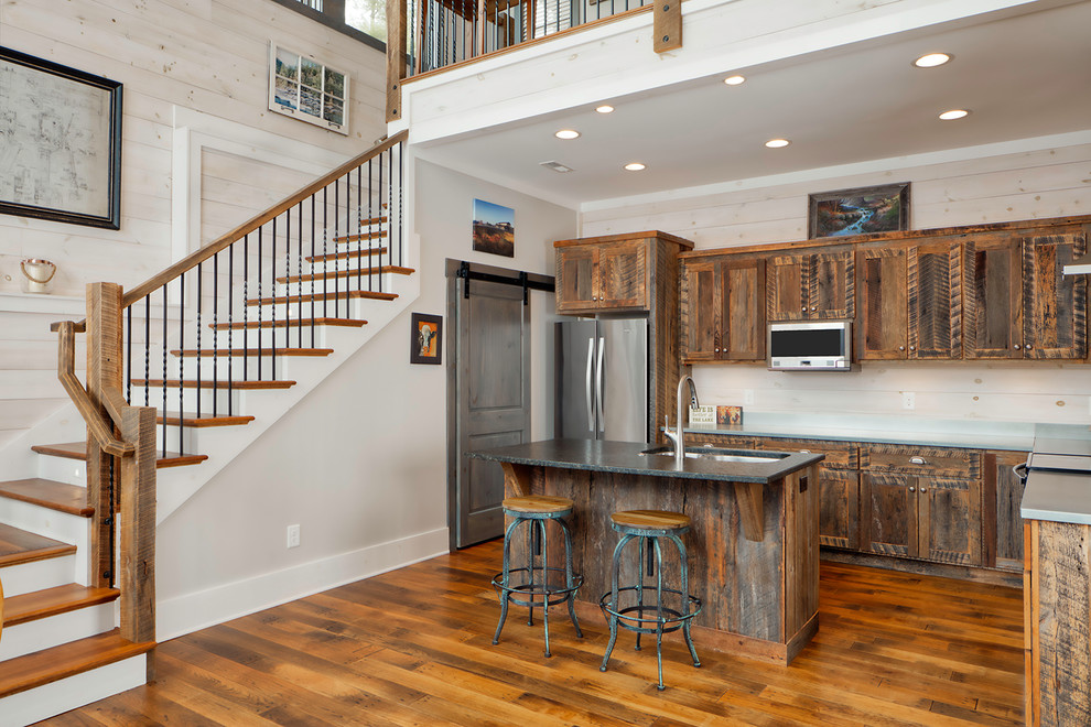 Foto på ett mellanstort rustikt grå kök, med en undermonterad diskho, skåp i shakerstil, skåp i mellenmörkt trä, vitt stänkskydd, stänkskydd i trä, rostfria vitvaror, mellanmörkt trägolv, en köksö och brunt golv
