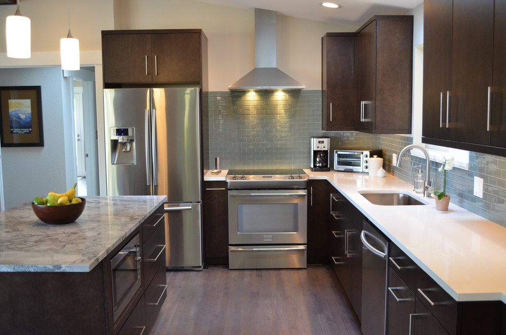 Example of a mid-sized trendy l-shaped dark wood floor and brown floor eat-in kitchen design in Seattle with an undermount sink, flat-panel cabinets, dark wood cabinets, blue backsplash, stainless steel appliances, an island, quartzite countertops and subway tile backsplash