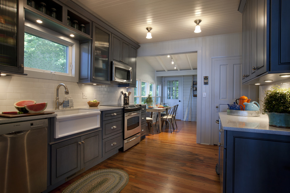 Стильный дизайн: кухня в классическом стиле с с полувстраиваемой мойкой (с передним бортиком), синими фасадами, белым фартуком и фартуком из плитки кабанчик - последний тренд