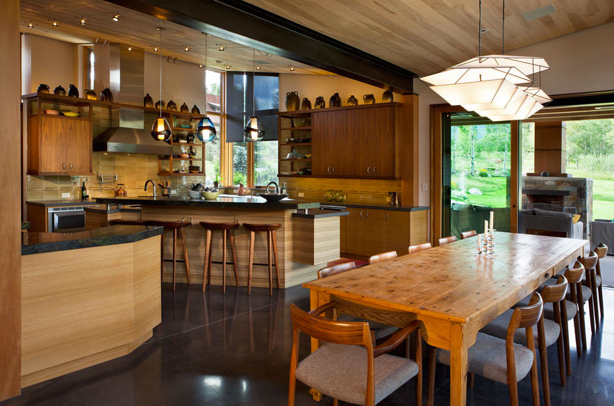 На фото: огромная параллельная кухня-гостиная в восточном стиле с плоскими фасадами, фасадами цвета дерева среднего тона, бежевым фартуком, бетонным полом и двумя и более островами с