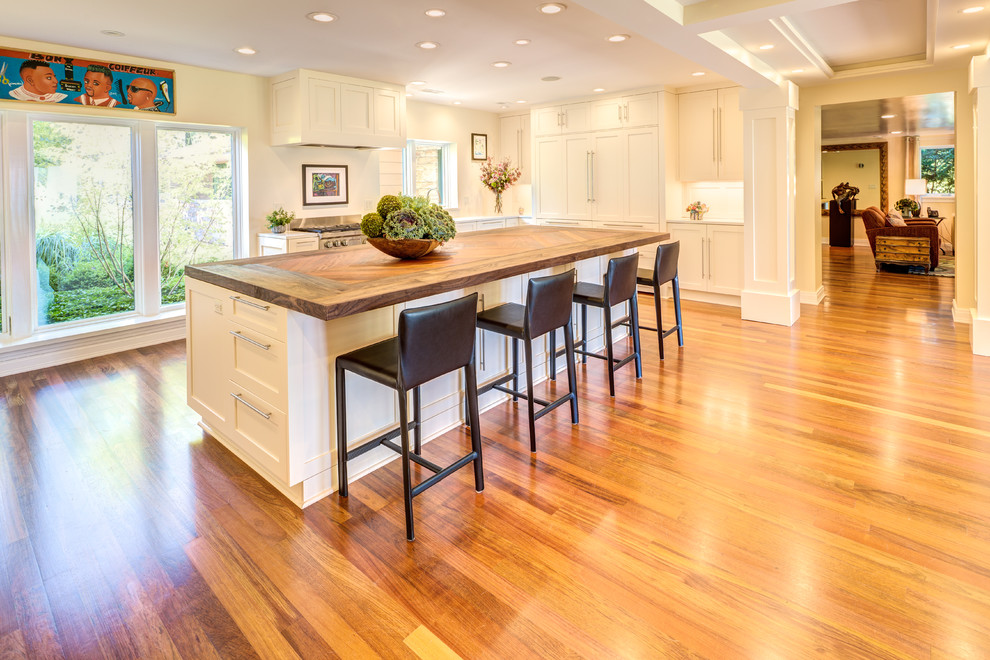 Exempel på ett stort modernt brun brunt kök, med en undermonterad diskho, luckor med infälld panel, vita skåp, träbänkskiva, rostfria vitvaror, mellanmörkt trägolv, en köksö och brunt golv