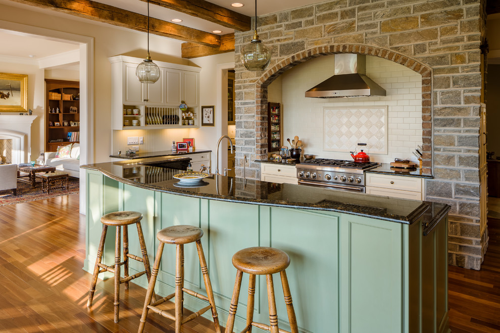Exempel på ett rustikt kök, med luckor med profilerade fronter, gröna skåp, beige stänkskydd, rostfria vitvaror, mellanmörkt trägolv och en köksö