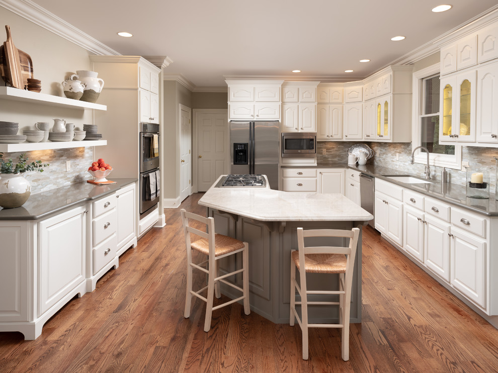 Offene, Mittelgroße Klassische Küche mit weißen Schränken, Quarzwerkstein-Arbeitsplatte, braunem Holzboden, Kücheninsel und braunem Boden in Sonstige