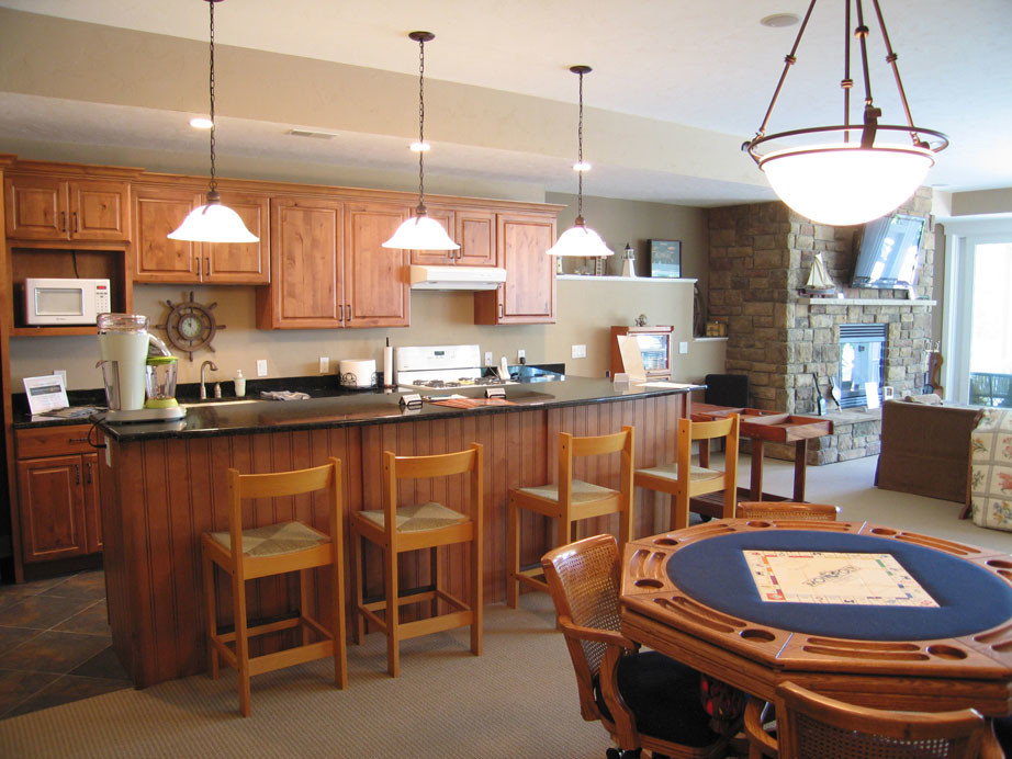 Exemple d'une cuisine ouverte linéaire chic en bois brun de taille moyenne avec un évier encastré, un placard avec porte à panneau surélevé, un plan de travail en granite, un électroménager blanc et îlot.