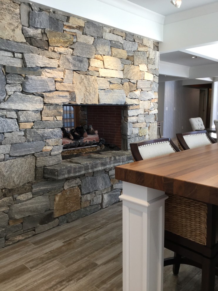 Example of a mid-sized beach style l-shaped ceramic tile and brown floor eat-in kitchen design in Chicago with a farmhouse sink, beaded inset cabinets, white cabinets, marble countertops, blue backsplash, glass tile backsplash, stainless steel appliances, an island and blue countertops