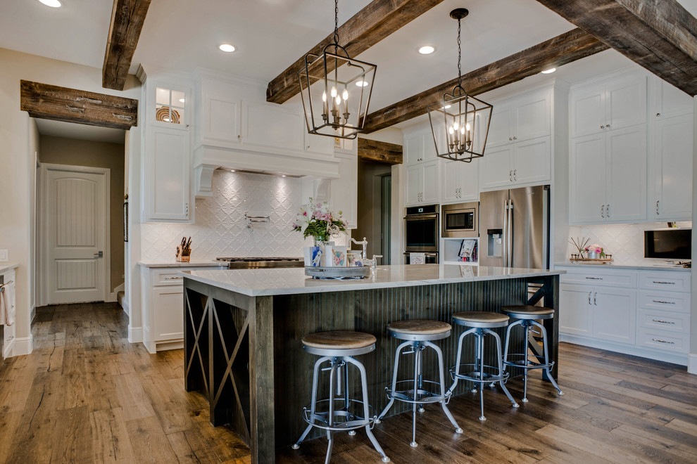 Example of a large classic u-shaped medium tone wood floor and brown floor eat-in kitchen design in Dallas with a farmhouse sink, beaded inset cabinets, white cabinets, quartzite countertops, white backsplash, ceramic backsplash, paneled appliances, an island and white countertops