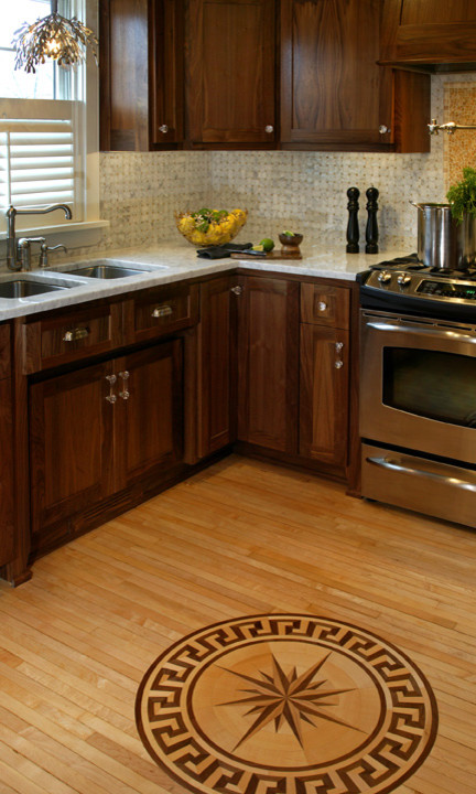 Modern inredning av ett kök, med en dubbel diskho, skåp i shakerstil, skåp i mörkt trä, granitbänkskiva, grått stänkskydd, stänkskydd i mosaik, rostfria vitvaror och ljust trägolv
