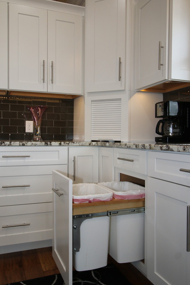 Exempel på ett stort klassiskt kök, med en dubbel diskho, skåp i shakerstil, vita skåp, granitbänkskiva, grått stänkskydd, stänkskydd i tunnelbanekakel, rostfria vitvaror, mellanmörkt trägolv och en köksö
