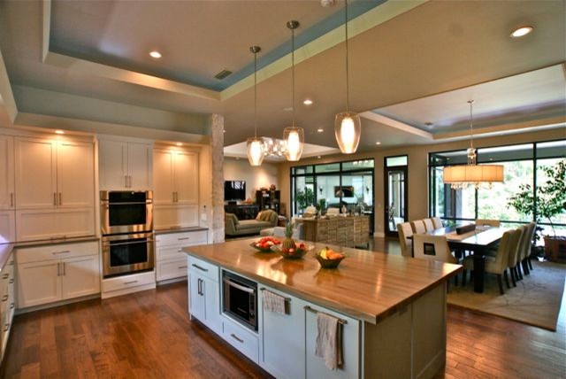Immagine di una cucina minimalista di medie dimensioni con ante in stile shaker, top in legno, paraspruzzi bianco, paraspruzzi con piastrelle a mosaico, elettrodomestici in acciaio inossidabile, lavello sottopiano, ante bianche, parquet scuro e pavimento marrone
