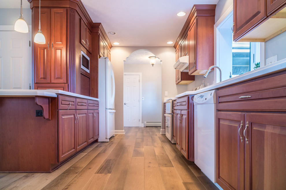 Ejemplo de cocina costera con puertas de armario de madera en tonos medios, suelo de madera clara y suelo marrón
