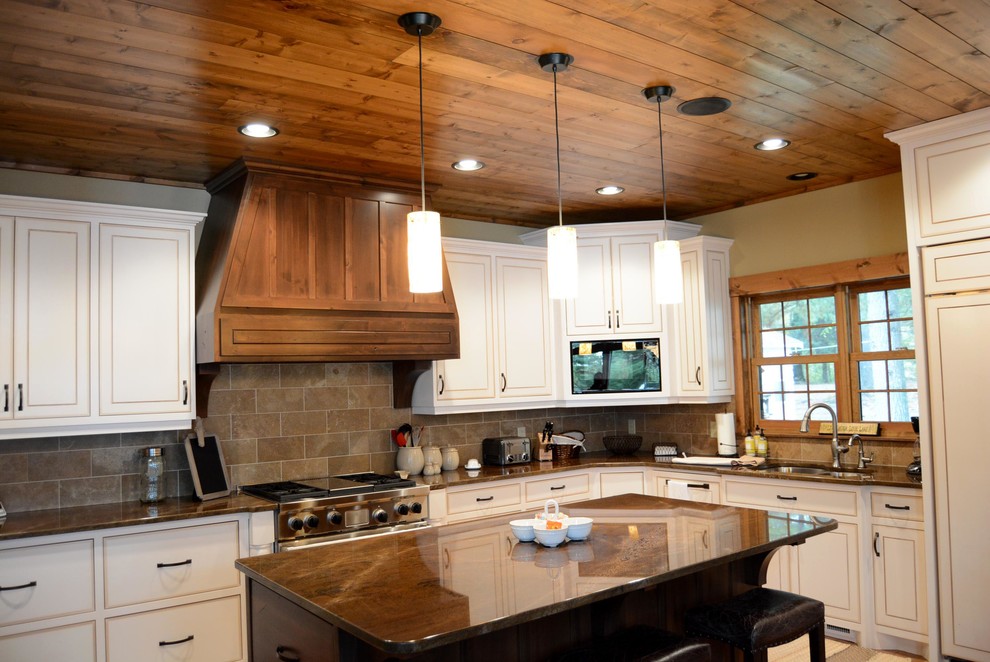 Rustik inredning av ett stort kök, med en dubbel diskho, släta luckor, vita skåp, granitbänkskiva, grått stänkskydd, stänkskydd i stenkakel, färgglada vitvaror, mellanmörkt trägolv och en köksö