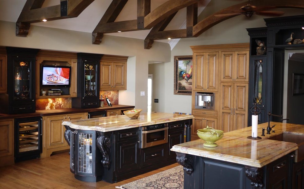 Large eclectic medium tone wood floor open concept kitchen photo in Other with a farmhouse sink, raised-panel cabinets, black cabinets, granite countertops, multicolored backsplash, stone slab backsplash, stainless steel appliances and two islands