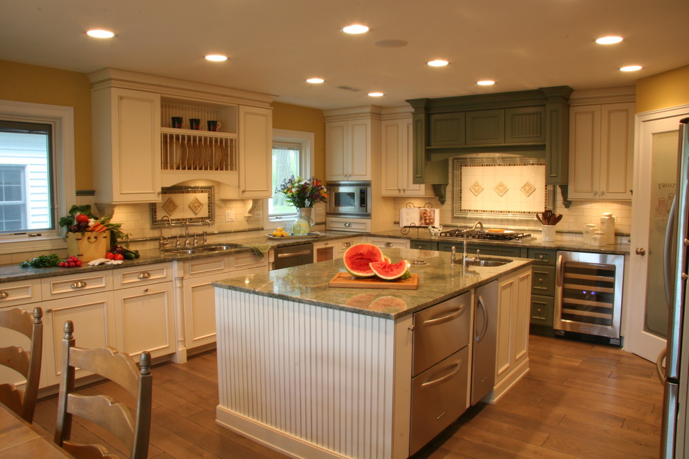 Inspiration for a mid-sized country u-shaped medium tone wood floor enclosed kitchen remodel in Chicago with an undermount sink, ceramic backsplash, an island, recessed-panel cabinets, beige cabinets, granite countertops, beige backsplash and stainless steel appliances