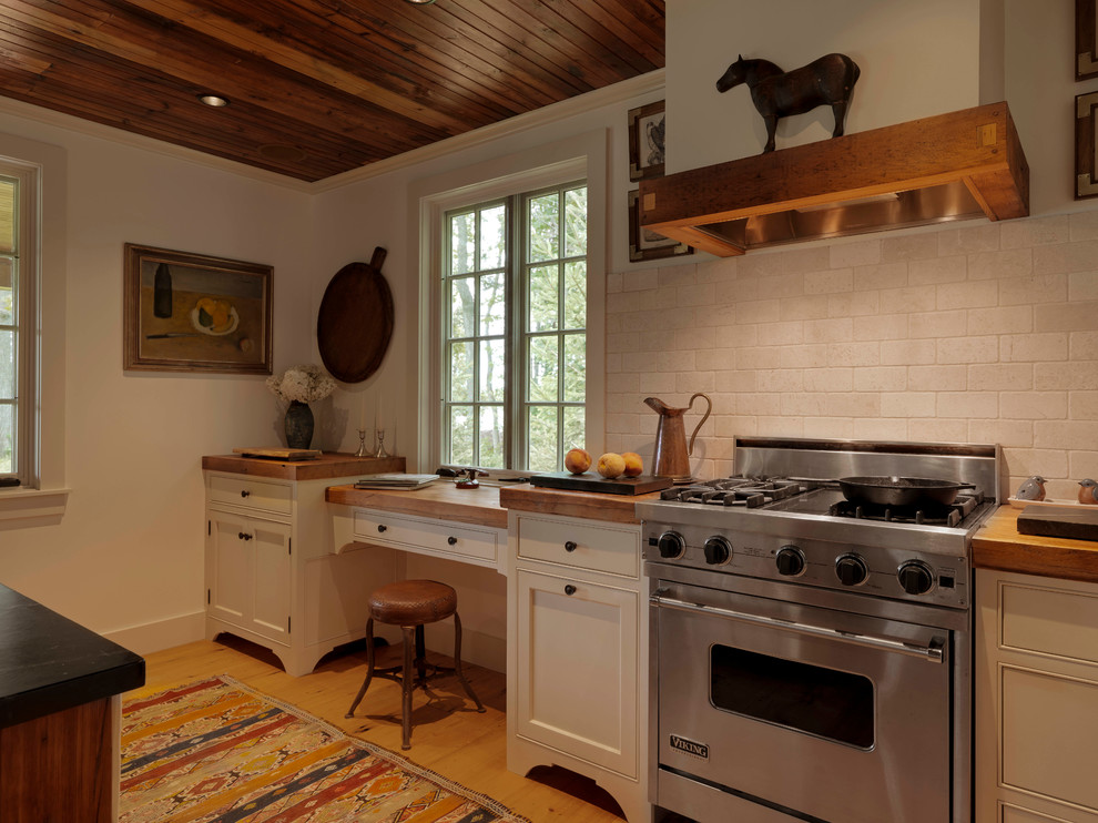 Idéer för mellanstora rustika linjära kök, med en rustik diskho, skåp i shakerstil, träbänkskiva, vitt stänkskydd, stänkskydd i stenkakel, rostfria vitvaror, ljust trägolv, en köksö och vita skåp