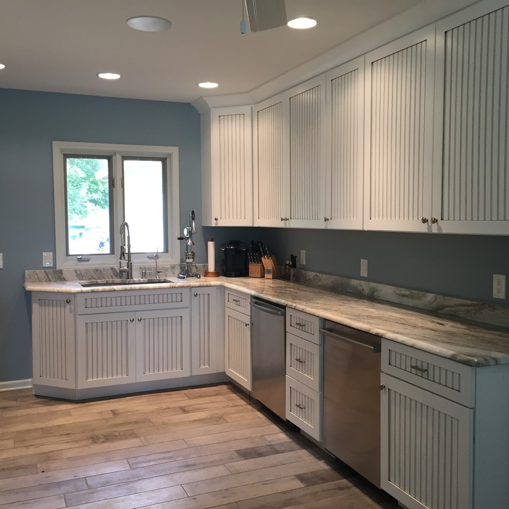 Enclosed kitchen - large coastal u-shaped vinyl floor and beige floor enclosed kitchen idea in Grand Rapids with an undermount sink, shaker cabinets, white cabinets, quartzite countertops, stainless steel appliances, no island and gray countertops