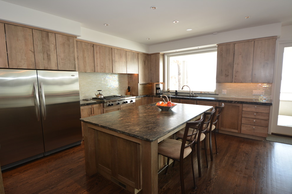 Foto på ett funkis kök, med granitbänkskiva, rostfria vitvaror, mörkt trägolv och en köksö