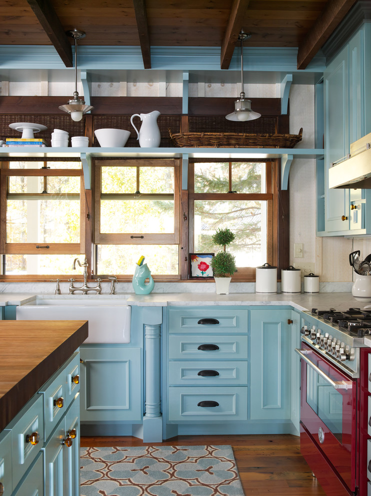 Idéer för lantliga kök, med en rustik diskho, luckor med infälld panel, blå skåp, färgglada vitvaror, mörkt trägolv och en köksö