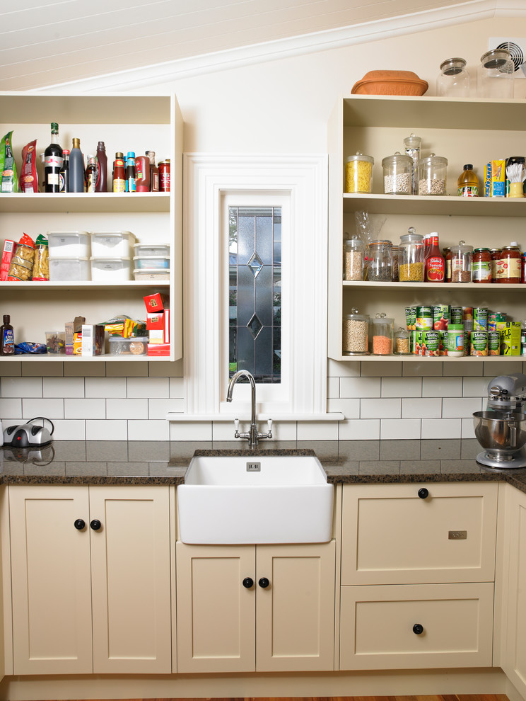 Immagine di una cucina chic di medie dimensioni con lavello da incasso, ante di vetro, ante bianche, top in marmo, paraspruzzi bianco, paraspruzzi in mattoni, parquet chiaro, pavimento marrone e top marrone