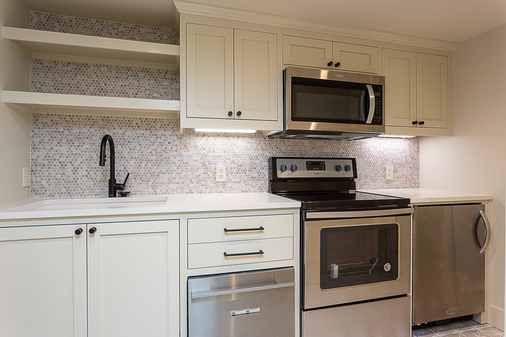Immagine di una cucina lineare chic di medie dimensioni con lavello a vasca singola, ante in stile shaker, ante bianche, top in superficie solida, paraspruzzi multicolore, paraspruzzi con piastrelle a mosaico, elettrodomestici in acciaio inossidabile e top bianco