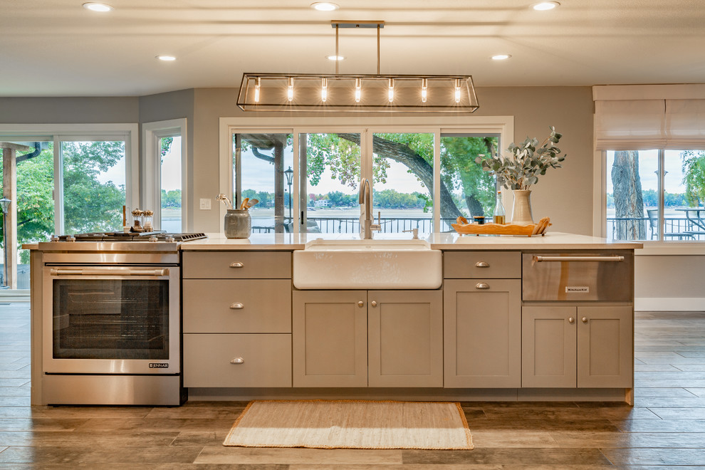 Example of a large cottage ceramic tile and gray floor open concept kitchen design in Denver with a farmhouse sink, shaker cabinets, gray cabinets, quartzite countertops, white backsplash, brick backsplash, stainless steel appliances, an island and white countertops