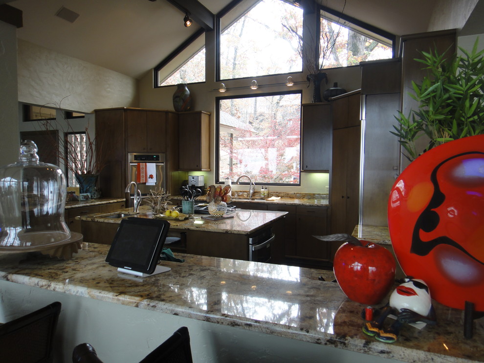 Photo of a large bohemian open plan kitchen in Little Rock with a submerged sink, flat-panel cabinets, brown cabinets, granite worktops, beige splashback, stainless steel appliances, porcelain flooring and multiple islands.