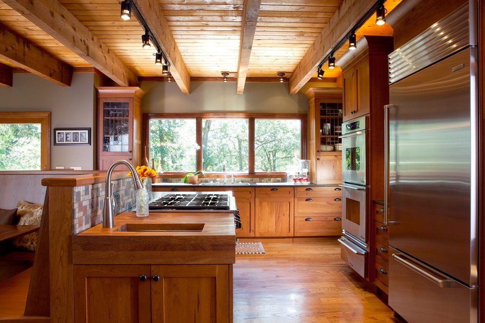 アトランタにあるトラディショナルスタイルのおしゃれなキッチン (シルバーの調理設備、木材カウンター、シェーカースタイル扉のキャビネット、中間色木目調キャビネット) の写真
