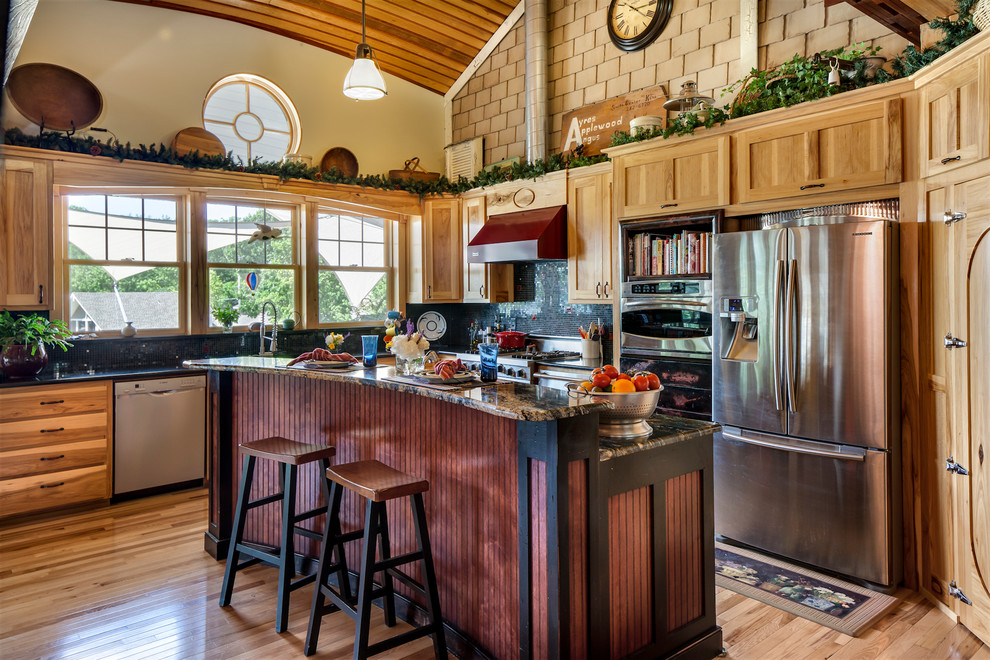 Example of a beach style kitchen design in Kansas City with shaker cabinets, medium tone wood cabinets and stainless steel appliances