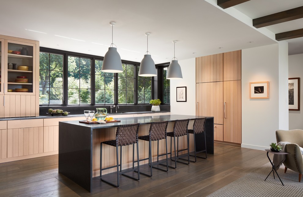 Photo of a traditional l-shaped open plan kitchen in Other with dark hardwood flooring, an island, brown floors, a submerged sink, medium wood cabinets, window splashback, integrated appliances and black worktops.
