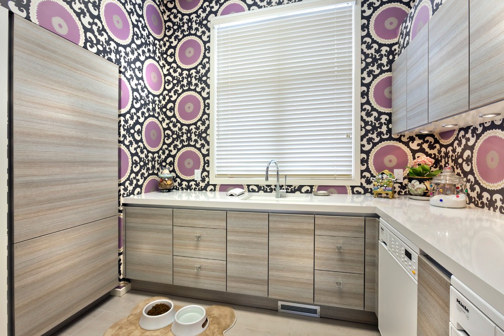 Enclosed kitchen - huge contemporary l-shaped porcelain tile enclosed kitchen idea in Minneapolis with a double-bowl sink, flat-panel cabinets, light wood cabinets, granite countertops, white backsplash, porcelain backsplash, paneled appliances and an island