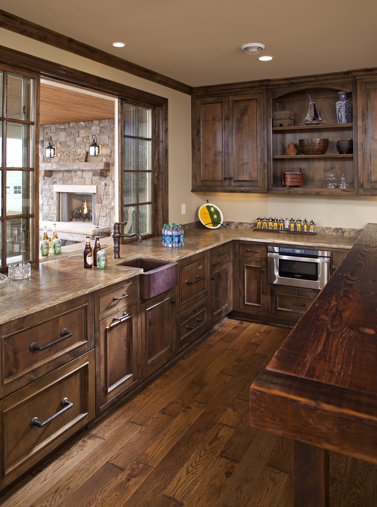 ミネアポリスにあるトラディショナルスタイルのおしゃれなキッチン (シングルシンク、落し込みパネル扉のキャビネット、濃色木目調キャビネット、シルバーの調理設備) の写真
