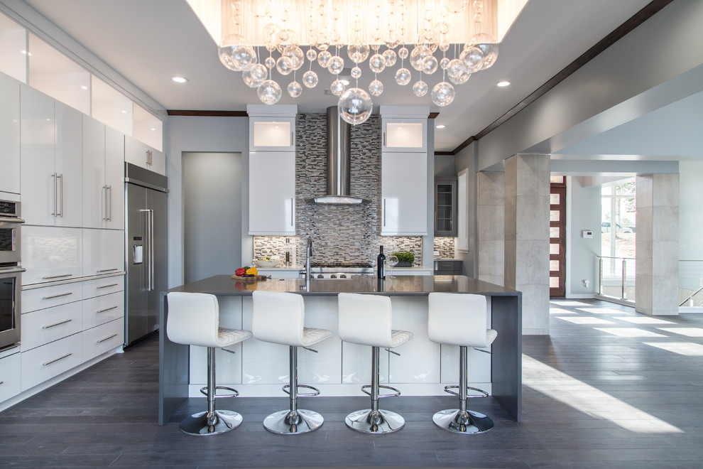Large contemporary kitchen in Charlotte with flat-panel cabinets, white cabinets, engineered stone countertops, multi-coloured splashback, mosaic tiled splashback, stainless steel appliances, dark hardwood flooring and an island.