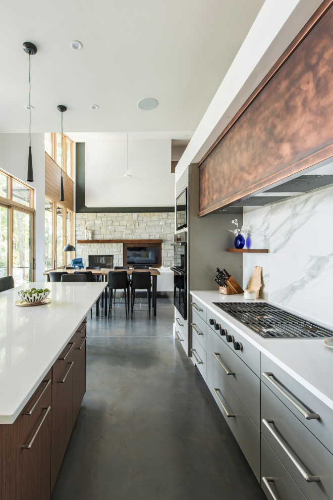 Inspiration for a mid-sized contemporary galley concrete floor and gray floor kitchen remodel in Atlanta with a farmhouse sink, flat-panel cabinets, gray cabinets, quartz countertops, white backsplash, marble backsplash, black appliances and white countertops