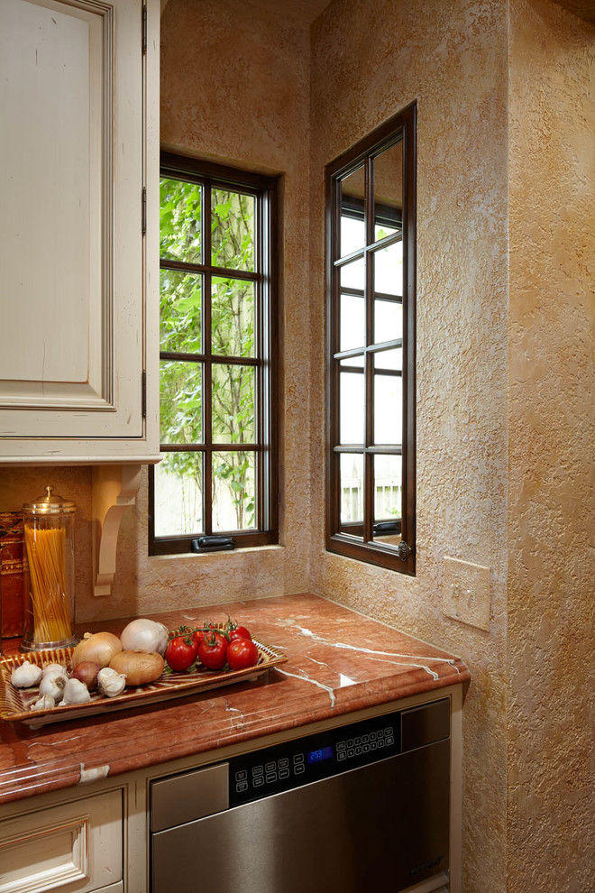 Cette photo montre une cuisine méditerranéenne avec un placard à porte affleurante, plan de travail en marbre, une crédence en mosaïque et un sol en bois brun.