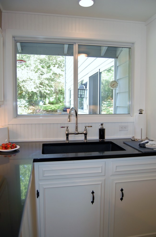 Exempel på ett avskilt, litet klassiskt u-kök, med en undermonterad diskho, luckor med infälld panel, vita skåp, bänkskiva i kvarts, vitt stänkskydd, vita vitvaror och linoleumgolv