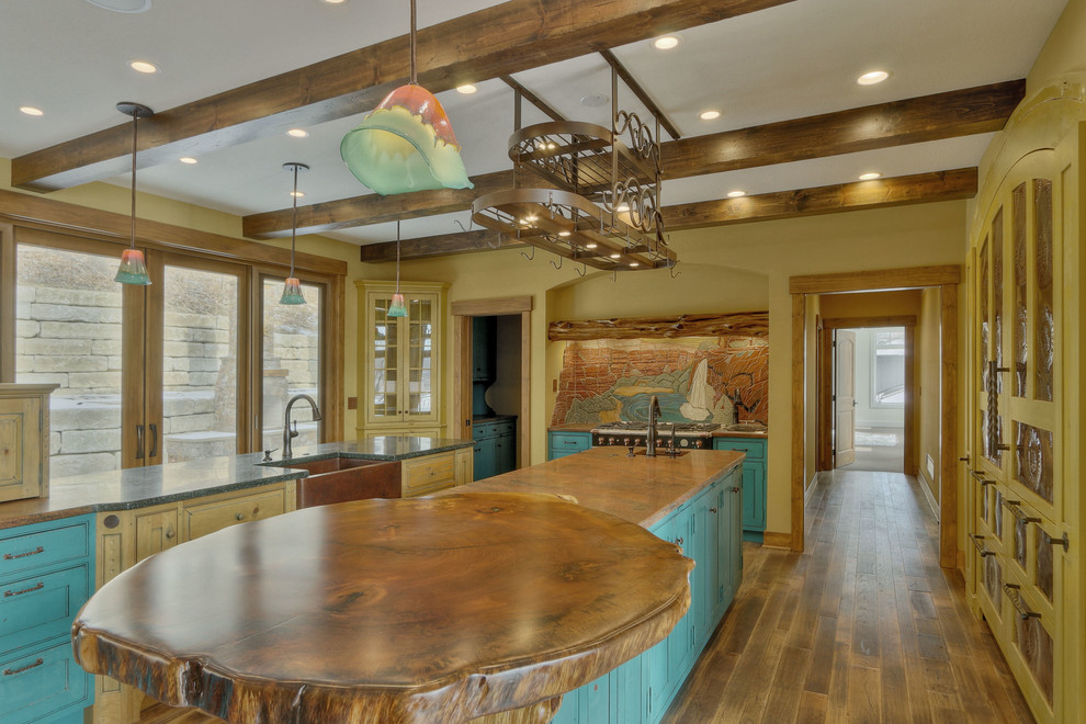 Inspiration for a large craftsman galley medium tone wood floor eat-in kitchen remodel in Kansas City with a farmhouse sink, flat-panel cabinets, blue cabinets, granite countertops, orange backsplash, colored appliances and two islands